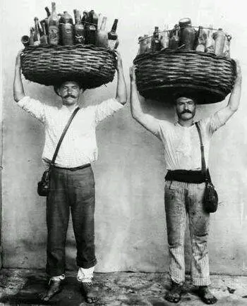 Dois homens seguram cestos com garrafas sobre a cabeça.