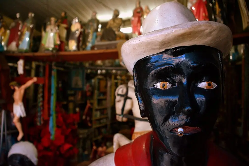 Santuário dedicado a Seu Zé Pelintra, figura malandra em preto, chapéu branco e camisa vermelha.
