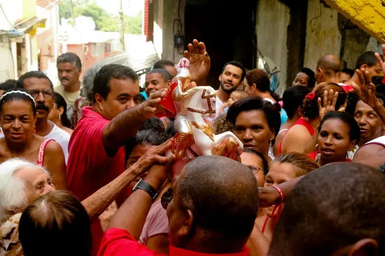 Multidão em rua urbana, São Jorge em destaque.