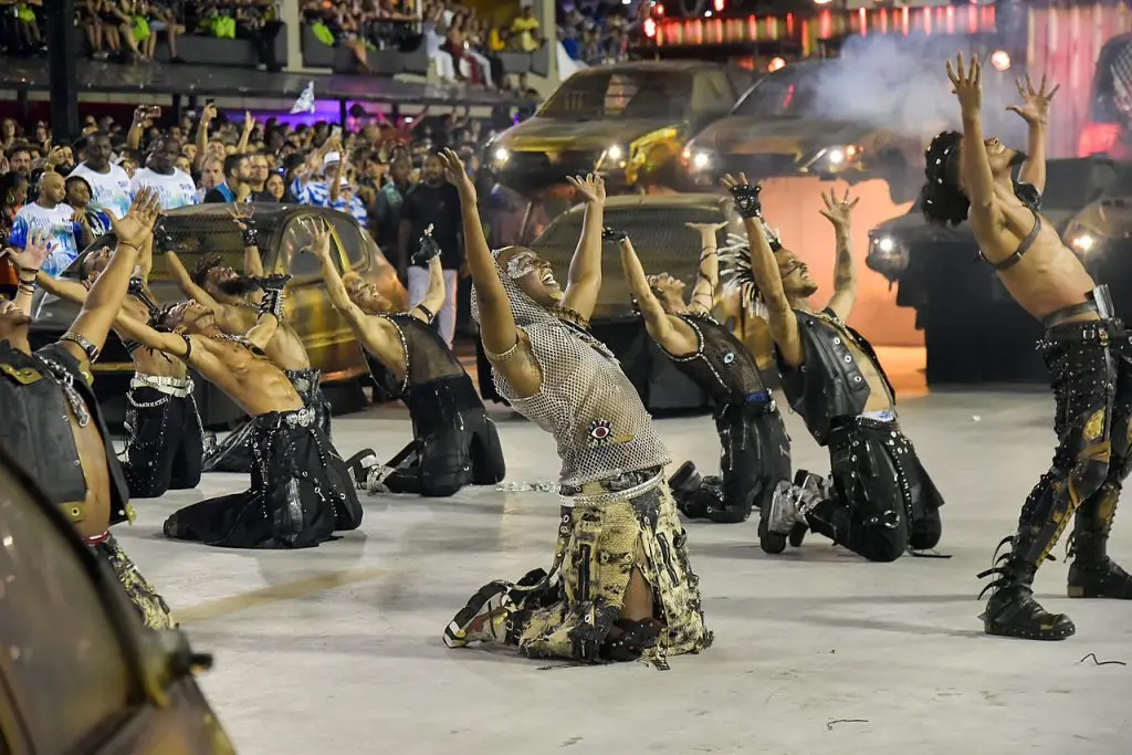 Desfile de Carnaval com participantes em trajes metálicos e alegres.