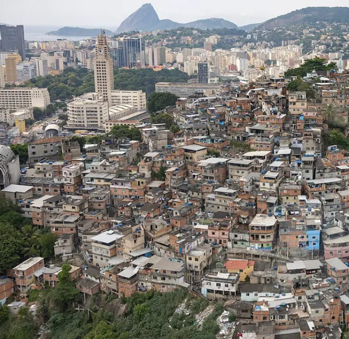Área urbana com edifícios altos e casas coloridas em colina.
