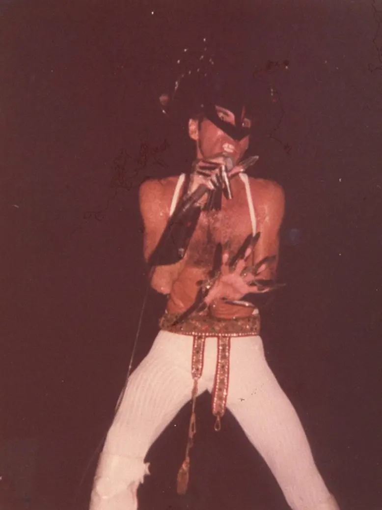 Ney Matogrosso, vestido com a malha colante branca, usa máscara e luvas de metal criadas e executadas por Mary Lashimoto no show Seu Tipo, Teatro Carlos Gomes, 1980