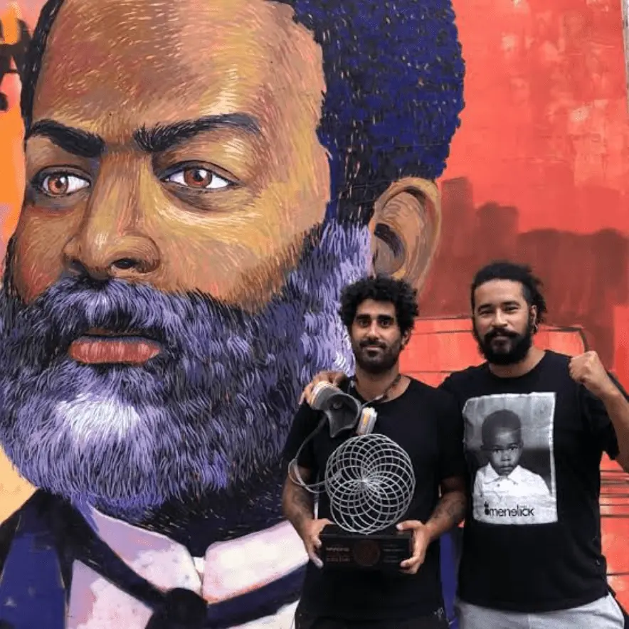 Cazé e Rajão em frente ao mural de Luiz Gama